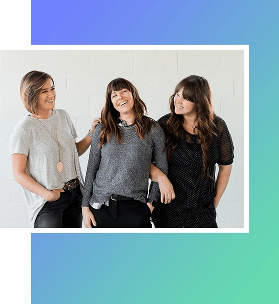 Three happy women laughing together.