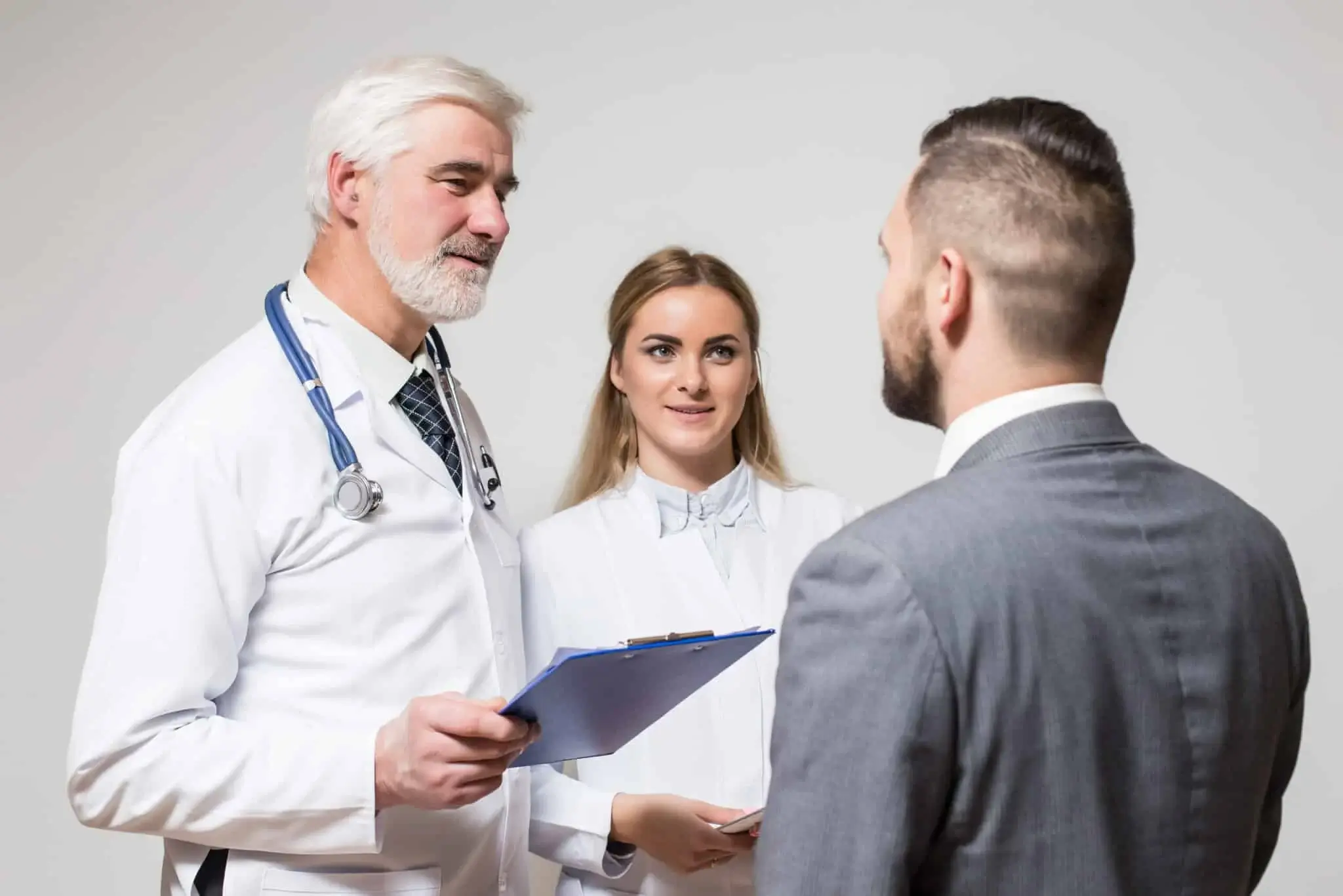 two doctors aged men and young woman with patient young business men