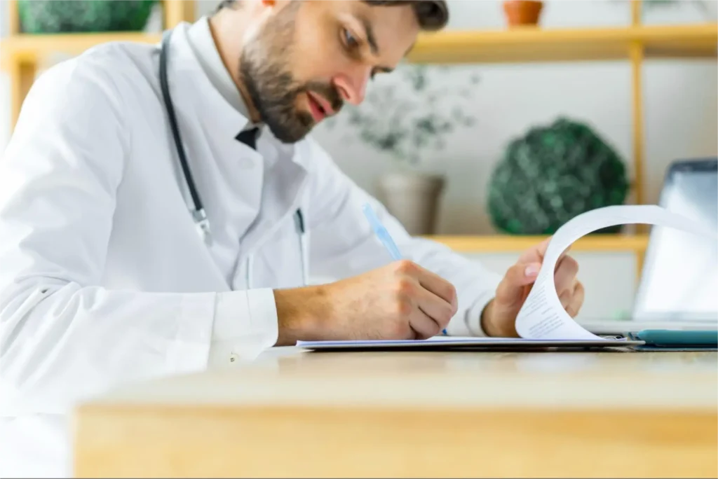 Doctor reviewing medical records at desk.