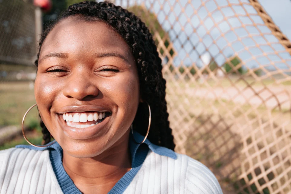 Joyful young woman smiling outdoors.